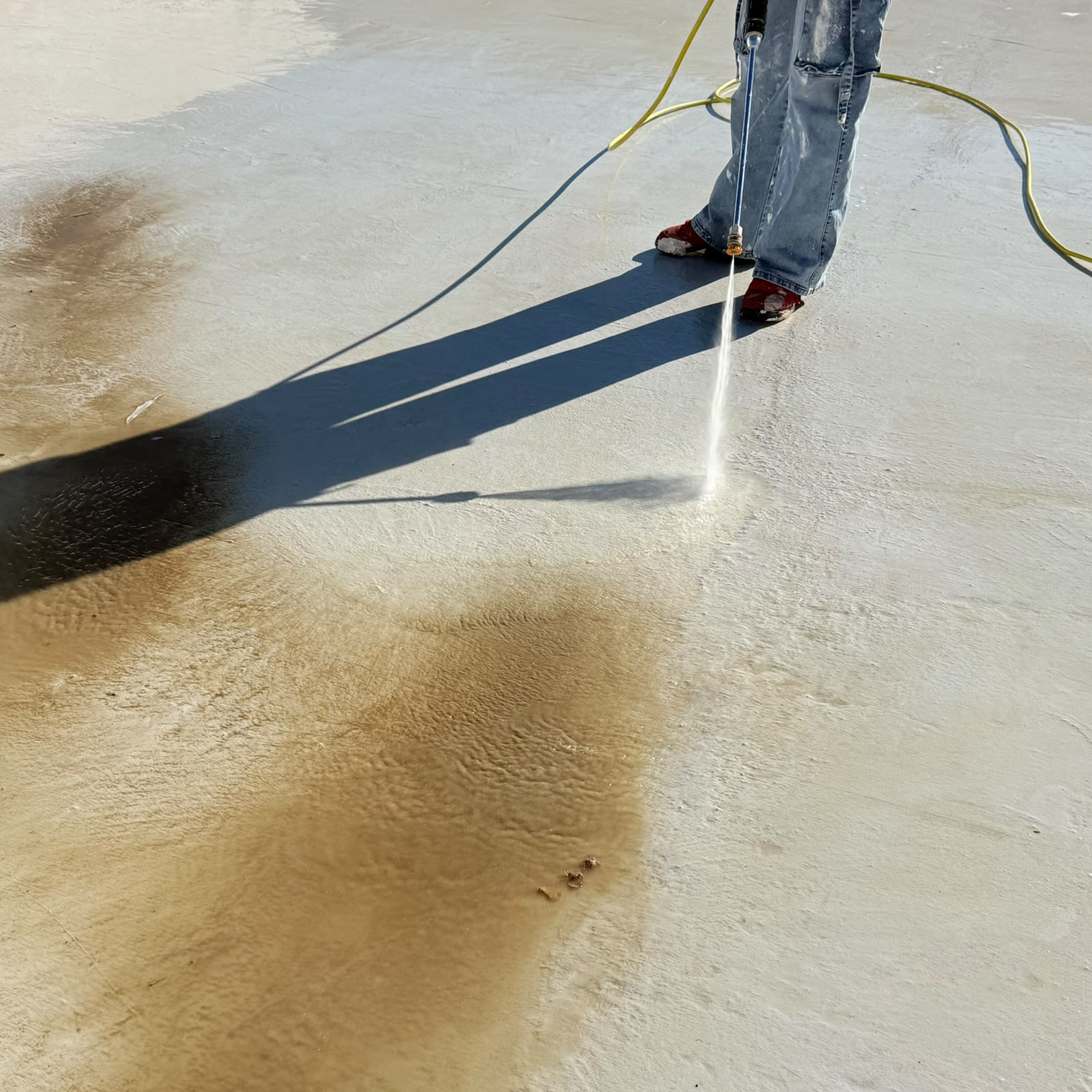 Trabajador lavando la losa a presión